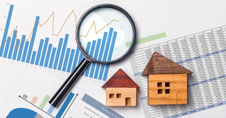 wooden houses and magnifying glass on spreadsheets GettyImages 1186618062 1200w 628h