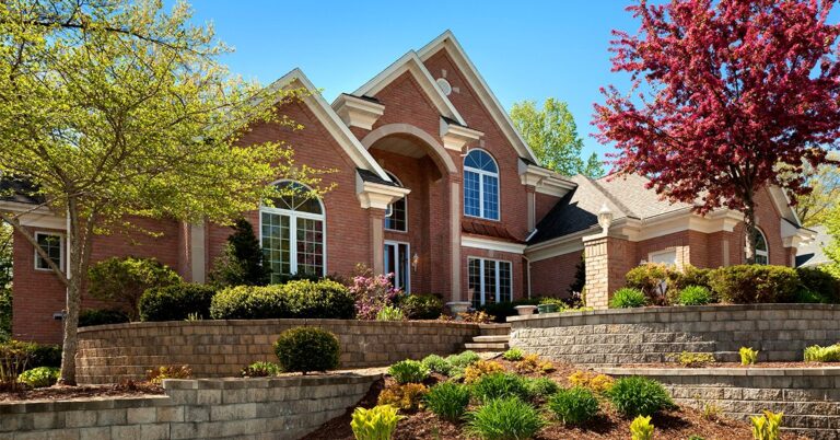 large modern brick house with landscaping in spring GettyImages 157593615 1200w 628h