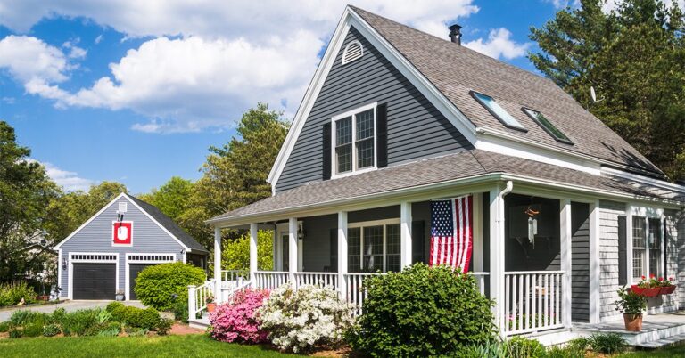 small gray house with porch us flag and garage gettyimages 496770244 1200w 628h